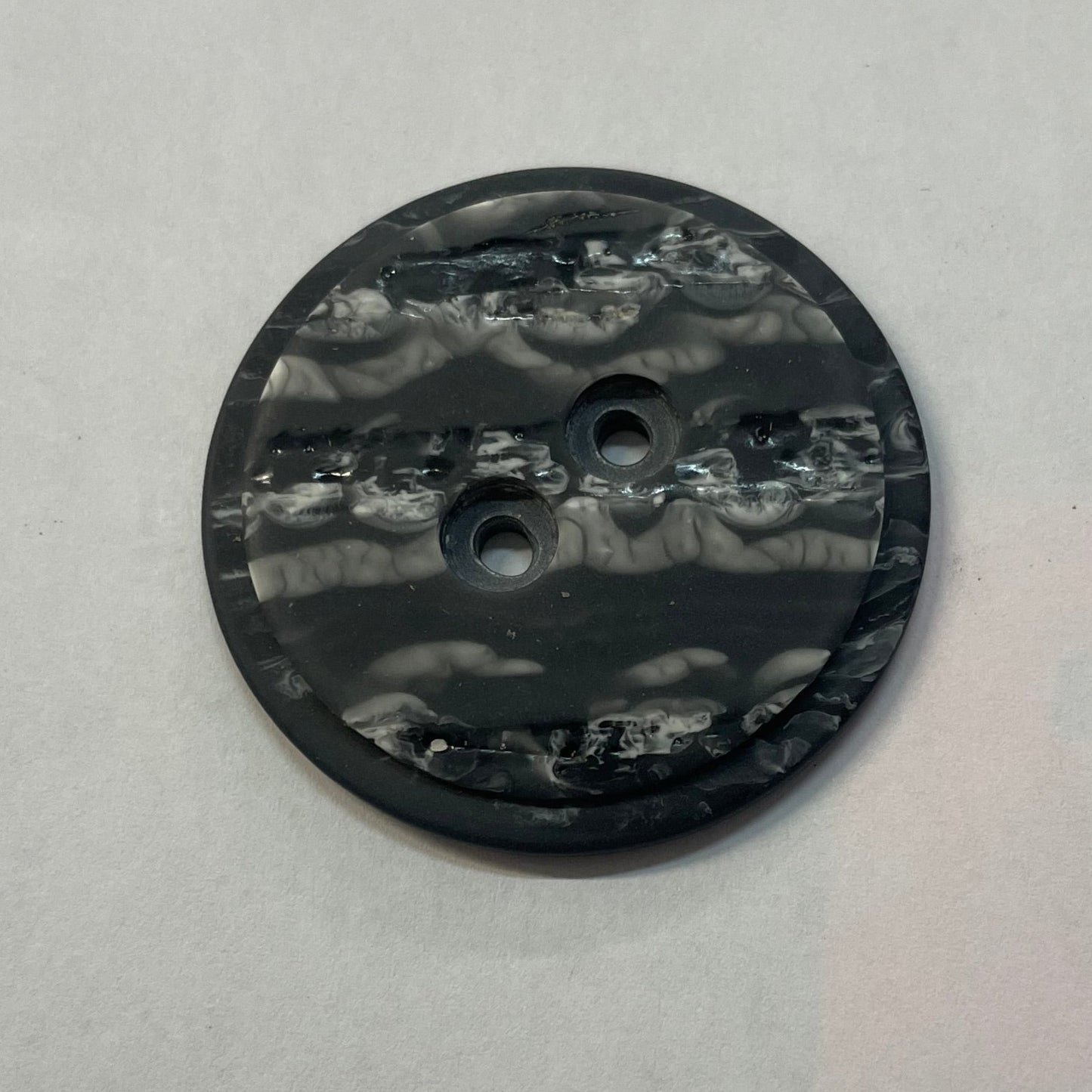 product photo of two-hole button in marbled grey plastic